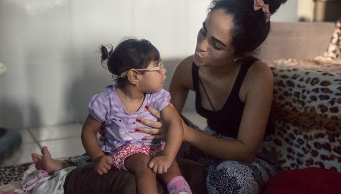 Dhulha Alen Silva do Nascimento and her daughter, Valentina, share a moment at home.