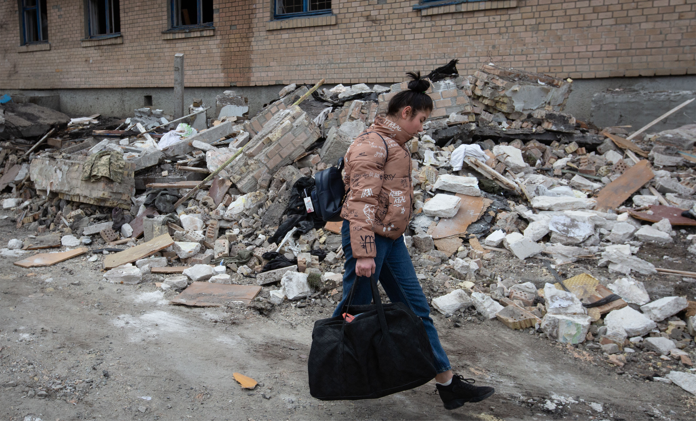 A local resident walks near a residential building destroyed by Russian drones attack in the town of Rzhyshchiv, Kyiv region, Ukraine on March 24, 2023. Photo by Oleksii Chumachenko/Anadolu Agency via Getty Images.
