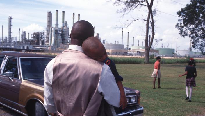A family leaving church services surrounded by chemical plants