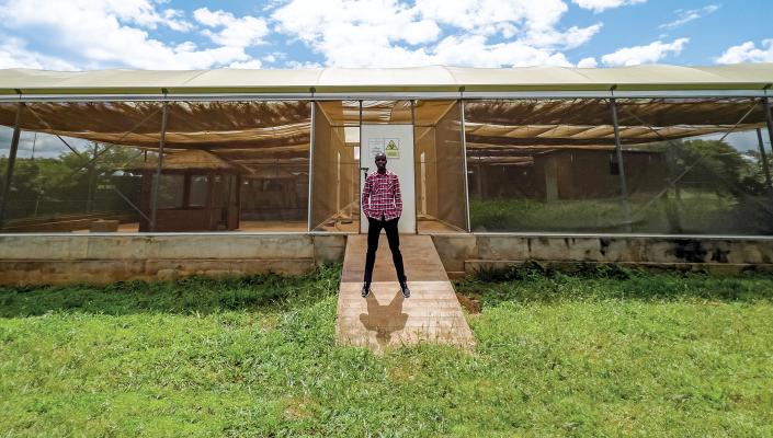 Entomologist Limonty Simubali stands in front of the “mosquito house” in Macha, Zambia, on March 30, 2022.