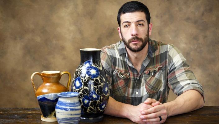 Adrian Weiss poses with some of his pottery.