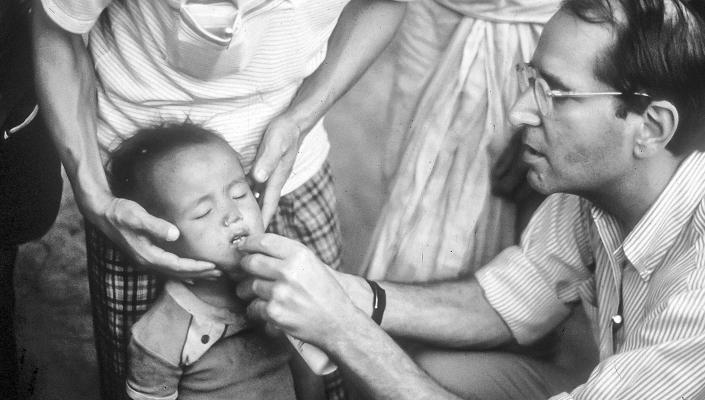 Al Sommer administers the contents of a vitamin A capsule in Nepal’s national vitamin A distribution campaign, c. 1985.