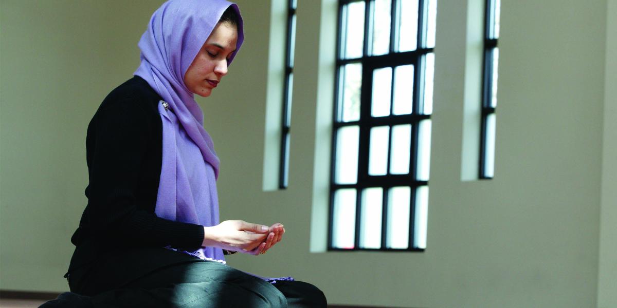 Maliha Ilias, doctoral student in Population and Family Health Sciences, kneels in prayer