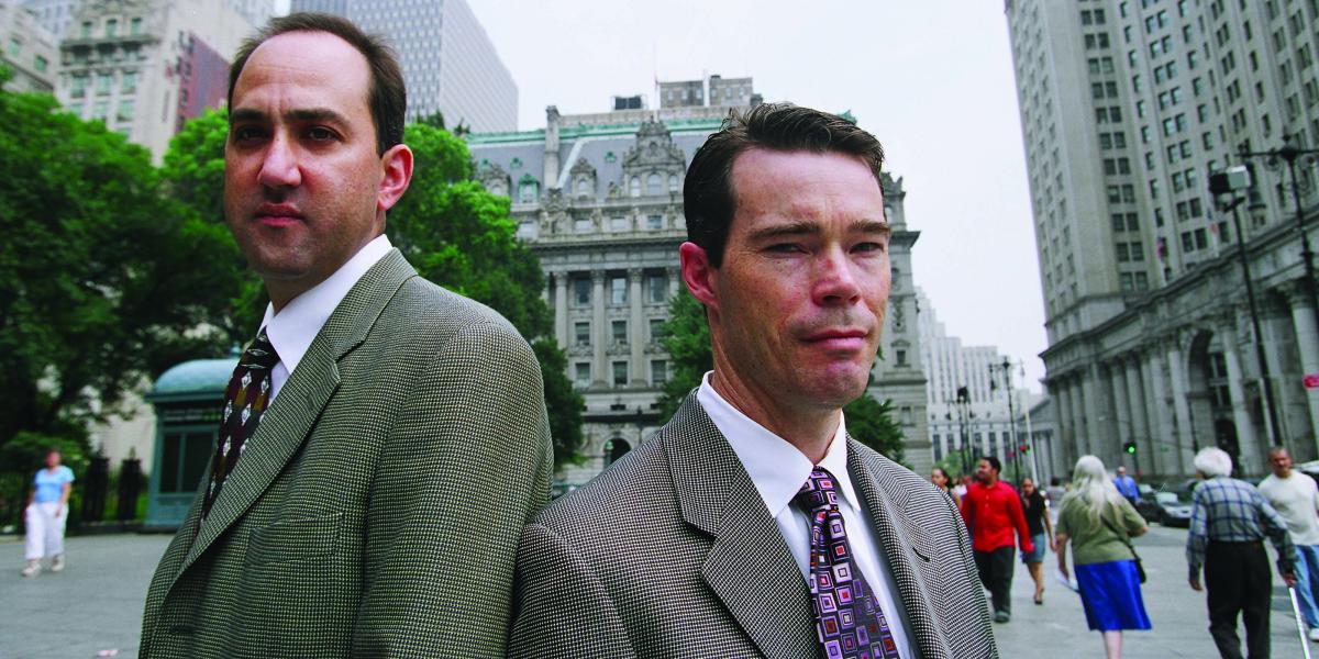 Jon Vernick and Daniel Webster stand back to back on a Baltimore street