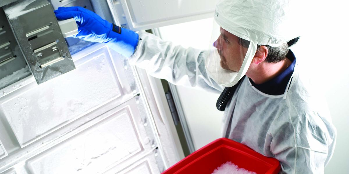 Andy Pekosz, in hazmat gear, removes a sample from a freezer