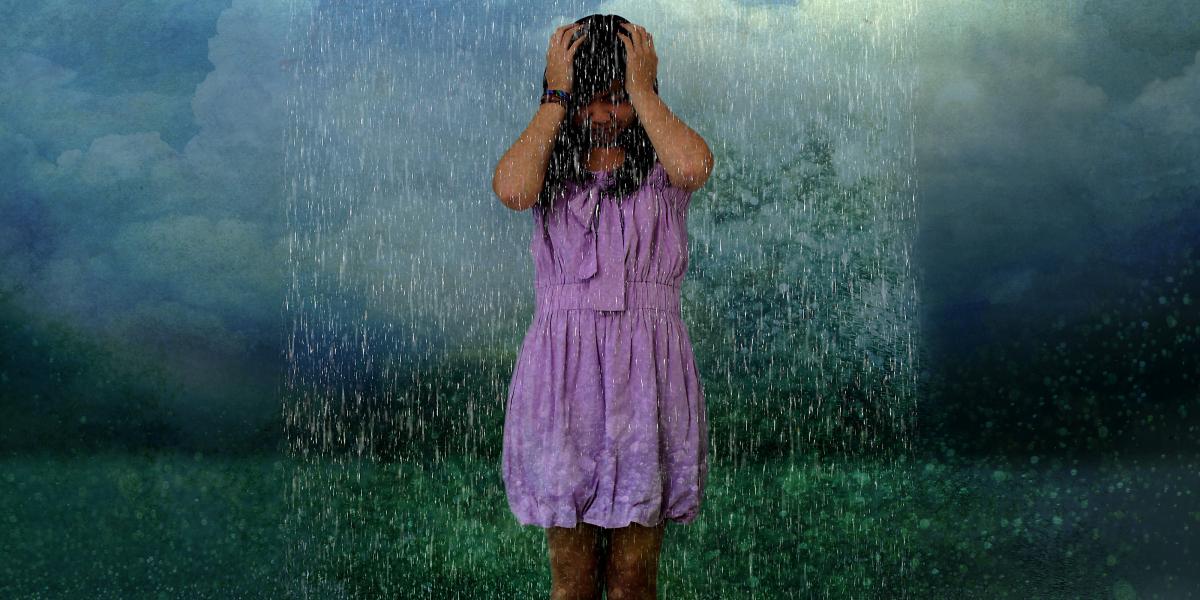 a teenage girl in a purple dress under a rain cloud