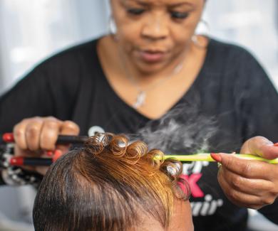 Katrina Randolph works on a client's hair in her salon.