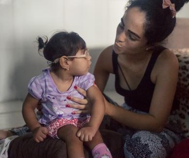 Dhulha Alen Silva do Nascimento and her daughter, Valentina, share a moment at home.