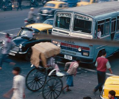 busy traffic scene with taxis, buses, and rickshaws