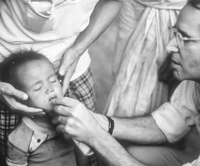 Al Sommer gives a small child vitamin A drops